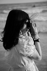 Young women are taking pictures in the sea.along the sand beaches flashes summer sun