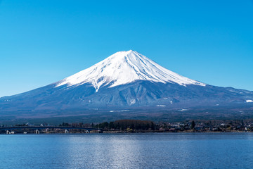 Fototapeta na wymiar Close up top of beautiful fuji mountain with snow cover on the top and blue cleared sky in morning, kawaguchiko lake, yamanashi, japan in asia. Famous landmark of japan. Best attraction travel.