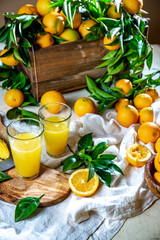 Table with box of fresh orange with orange tree branch and fresh orange juice