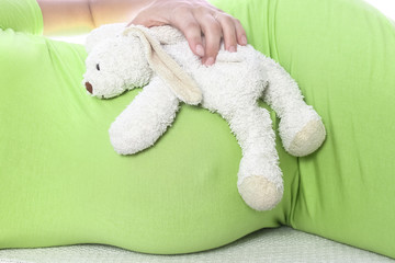 Happy pregnant girl lies on white background