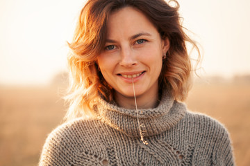 Portrait joyful young woman   brunette in brown knit sweater made of natural wool and jeans holding...