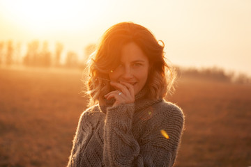 Portrait joyful young woman   brunette in brown knit sweater made of natural wool and jeans holding...