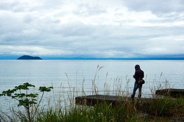 Fototapeta na wymiar A man standing on the side of Lake Biwa. びわ湖のサイドに立つ男