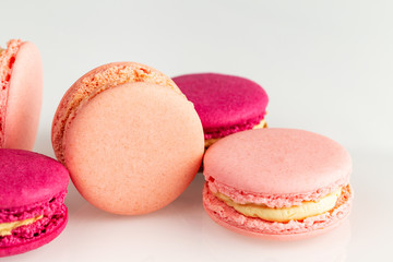 French pink macarons or macaroons closeup, side top view on a white background.