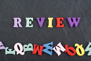 REVENUE word on black board background composed from colorful abc alphabet block wooden letters, copy space for ad text. Learning english concept.