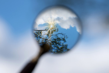 Wolken, Sonne und Himmel betrachtet durch eine Lupe
