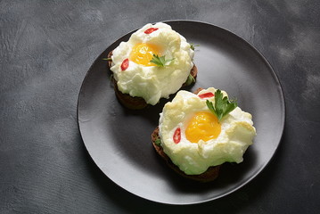 Delicate baked egg. Orsini eggs in the cloud. French breakfast.Cloud egg on toast 
