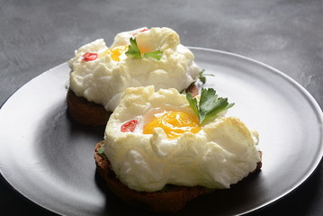 Delicate baked egg. Orsini eggs in the cloud. French breakfast.Cloud egg on toast 