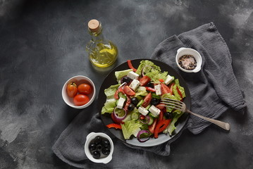 Greek salad with fresh cucumber, cherry tomatoes, sweet pepper, lettuce,red onion, olives and olive oil and feta cheese. Healthy food concept
