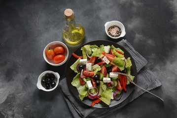 Greek salad with fresh cucumber, cherry tomatoes, sweet pepper, lettuce,red onion, olives and olive oil and feta cheese. Healthy food concept