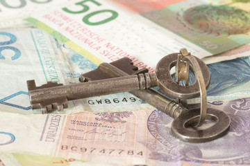 Ein Schlüssel, und Geldscheine Polnische Zloty und Schweizer Franken