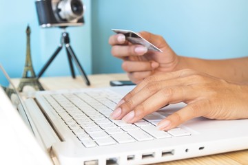 Woman's hands using laptop and credit card for booking or reservation hotel and flight for Paris