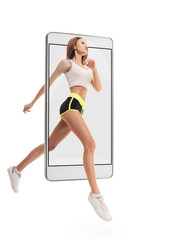 Portrait of young sporty energetic healthy woman running, concept virtual reality of the smartphone. going out of the device
