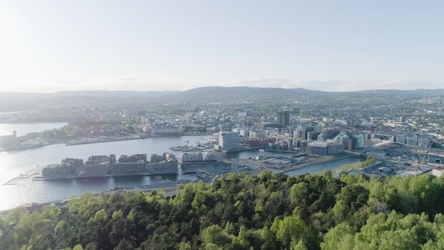 4K aerial of the Oslo city line with a backdrop of downtown Oslo and Bjoervika, a popular tourist attraction with the Munch museum, Barcode and Soerenga pier, in evening with forward motion.
