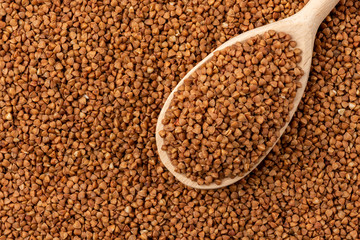 Buckwheat background with wooden spoon.