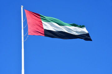 ABU DHABI.  National flag on blue sky background. United Arab Emirates