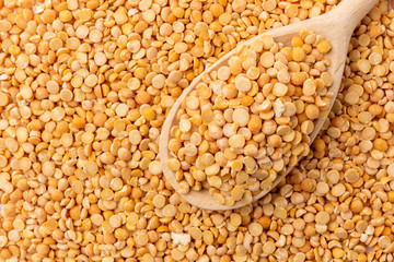Dried peas background with wooden spoon.