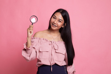 Young Asian woman with a magnifying glass.