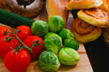 Fresh vegetables and fresh tomato,brussels sprouts, bread, cinnamon rolls, picture placement, still light, shadow