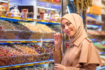 Beautiful muslim woman looks at spices and herbs