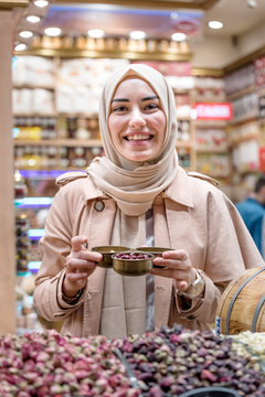 Beautiful muslim woman sells dried nuts