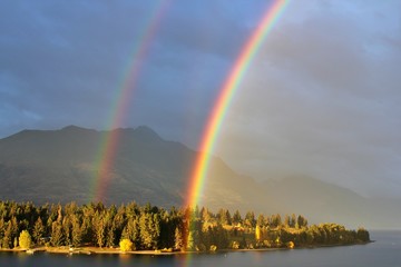 Bright beautiful real double rainbow in cloudy sky, Queenstown, New Zealand