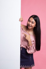 Young Asian woman point to a  blank sign.