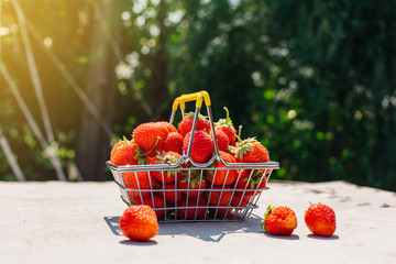 Mini shopping basket full of fresh red ripe strawberry on vintage background