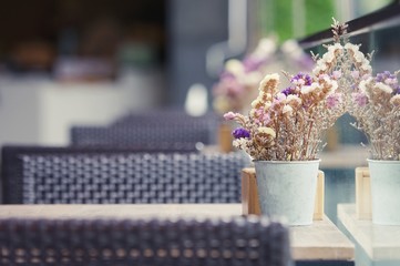 flower vase on wood table ,Still-Life with white hortensia flowers in vase outdoor, wood table and black chairs set up for lunch outside cafe