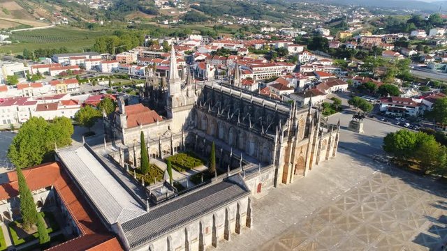 Aerial view ancient abbey in Batalha. Drone flying above dominican monastery moving around decorated towers and walls. Batalha, Portugal