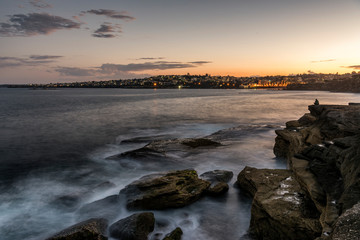 Clovelly coastline looking at night lights of Coogee beach Australia at sunset.