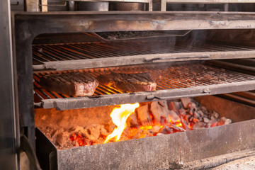 food, craft and delicious concept - cooking steak on a grill