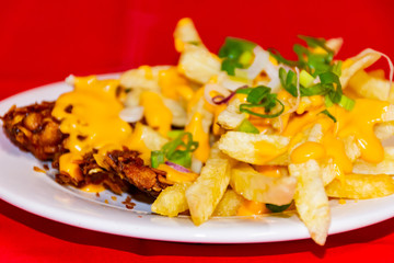 Potatoes and chicken with cheddar sauce and garnished with chives.