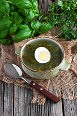 Soup with sorrel and eggs in bowl on the table