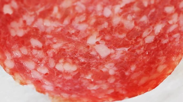 Smoked sausage, salami slice macro shot. Top view, Slow pan. Selective focus. Food texture, salami detail. Extreme closeup. 