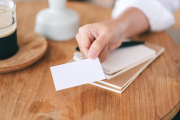 Obraz premium A woman holding and giving a blank empty business card to someone