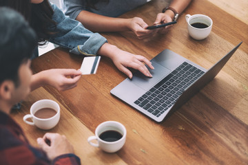 Three young asian people use credit card to purchasing and shopping online