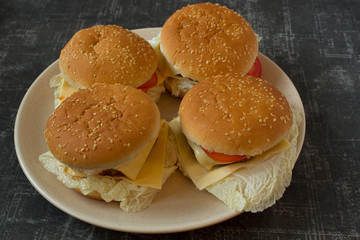 Four homemade burgers on a plate top view