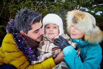 Obraz premium Happy family walking in a winter forest. New Year and Christmas concept
