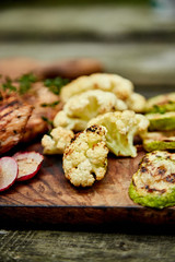 Grilled zucchini and cauliflower vegetable on wooden background . Vegan food. Diet, healthy Picnic. Summer. Top view. Flat lay. Copy space..