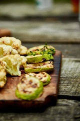 Grilled zucchini and cauliflower vegetable on wooden background . Vegan food. Diet, healthy Picnic. Summer. Top view. Flat lay. Copy space..