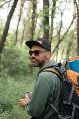 A young guy with a backpack in the cap, traveller in the woods, Hiking, Forest, Journey