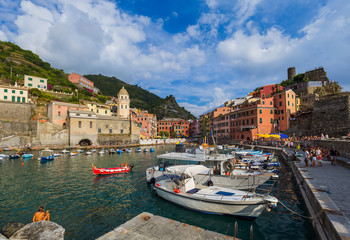 Fototapeta premium VERNAZZA, ITALY - AUGUST 17, 2016: Tourists walk by Vernazza in Cinque Terre on August 17, 2016 in Vernazza Italy