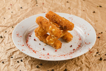 Cheese nuggets on plate on craft paper background
