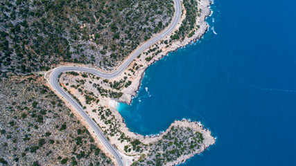 Aerial landscape of coastline and a road seascape. Car drives down the empty asphalt road running...