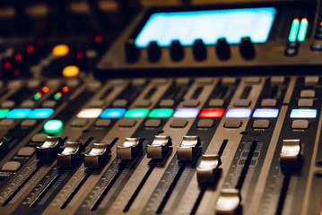Professional sound and audio mixer control panel with buttons and sliders. Sound recording studio...