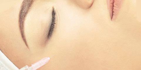 Woman face cosmetology treatment. Biorevitalization skin therapy. Doctor insert filler. Girl clinic...
