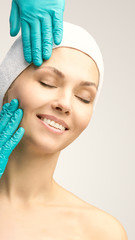 Female derma rejuvenate treatment. Doctor in gloves touch woman face. Cosmetology pretty portrait....