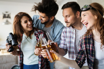 Group of happy young friends having fun and drinking beer