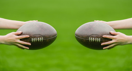A woman holds a rugby ball, isolated on a green background